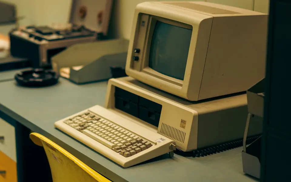 A vintage IBM desktop computer and keyboard on an office desk